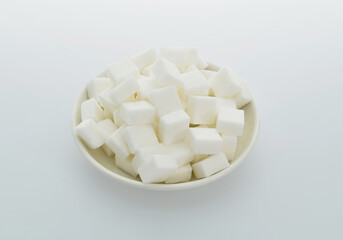 Sugar cubes on a plate on white background