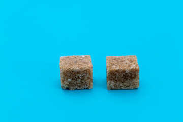 Brown sugar cubes on blue background