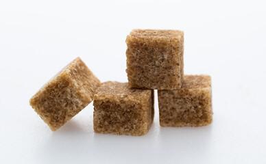 Brown sugar cubes on white background