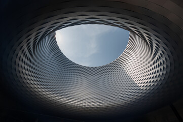 Messe Basel: Unveiling the Intricate Beauty of an Architectural Marvel, where Circular Patterns and Aluminum Panels Weave a Mesmerizing Tapestry around a Central Void - obrazy, fototapety, plakaty