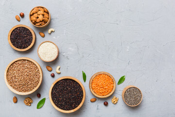 Various superfoods in smal bowl on colored background. Superfood as rice, chia, quinoa, lentils, nuts, sesame seeds, almonds. top view copy space