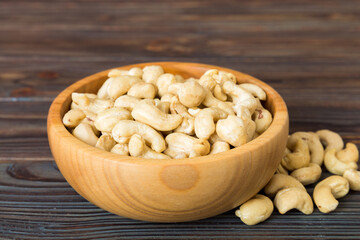 cashew nuts in wooden bowl on table background. top view. Space for text Healthy food