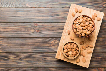 Fresh healthy Almond in bowl on colored table background. Top view