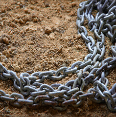An old metal chain lies on the ground