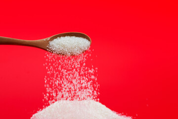 Sugar crystals falling out of wooden spoon