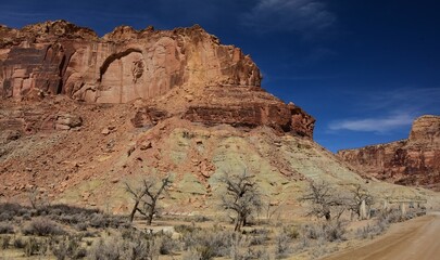 red rock  buttes and  the historic swinging bridge on a sunny winter day   in  san rafael river canyon along the buckhorn draw scenic backway in the northern san rafael swell near green river,  utah 