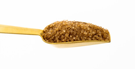 Metal scoop of brown sugar on white background