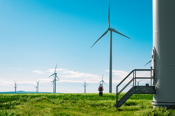 Person by wind turbine farm in the field