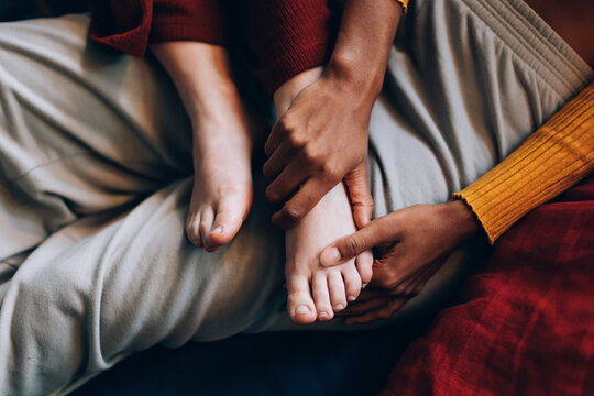 details of female hands taking care of female partner's foot - tender care in a lesbian relationship
