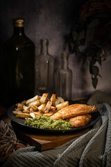 British Traditional Fish and chips with mashed mushy peas, in rustic setting 