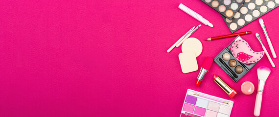 Make up set with colorful eyeshadow palettes, brushes, sponges and flowers. Viva magenta background