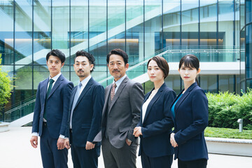 オフィス前に並ぶエグゼクティブビジネスパーソンのグループ
