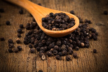 black pepper on wooden spoon