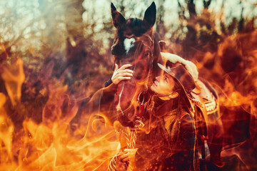 Young beautiful dreadded girl outdoors with her true horse. Fire background.