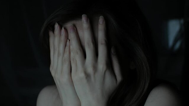 Woman is watching something scary. Close up scared girl face.