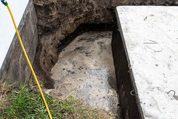 Concrete septic tank with a capacity of 10 cubic meters placed in the garden by the house, visible water below.