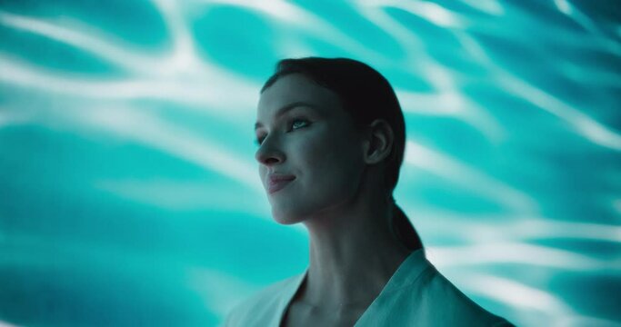 Cinematic Portrait with a Stylish Elegant Model in White Clothes Standing Inside a Abstract Underwater Room with Abstract Art Background. Young Female in a Beautiful Mystical Place