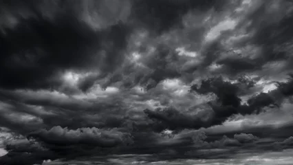 Fotobehang dark dramatic sky with black stormy clouds before rain or snow as abstract background, extreme weather, the sun shines through the clouds, high contrast photo © soleg