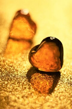 Amber glass hearts on glitter golden table