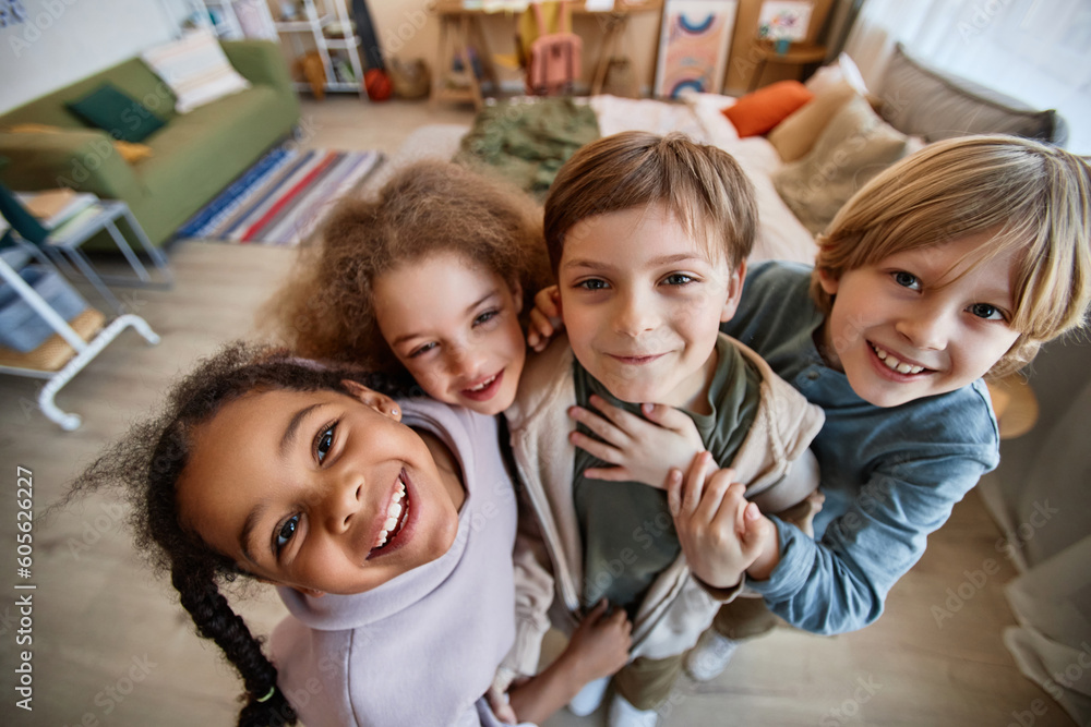 Wall mural top view fisheye at diverse group of happy children looking at camera together and smiling