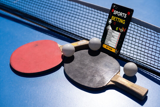 Smartphone on a blue table with ping pong rackets, rope and on background