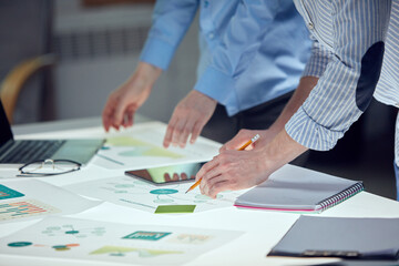 Team of entrepreneurs are brainstorming ideas on notes over table with documents. Agile...