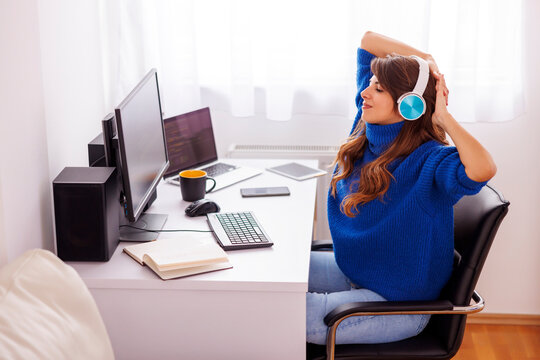 Woman stretching while sitting at her desk in home office