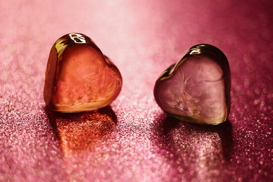 Amber glass hearts on glitter pink table