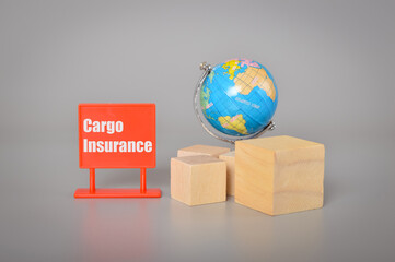 World globe, wooden blocks and plastic board with text CARGO INSURANCE.