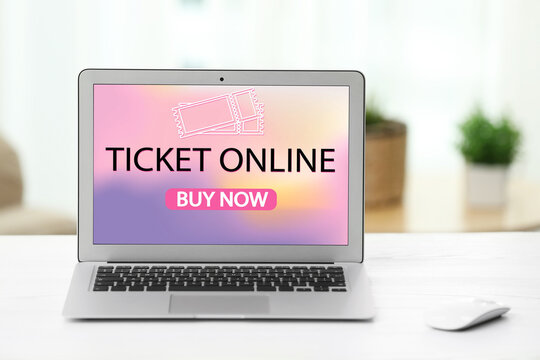 Buying tickets online. Laptop with open website or application on table