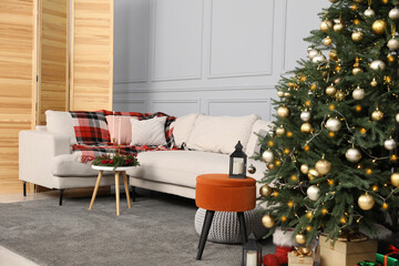 Beautiful Christmas tree, gift boxes and sofa in living room