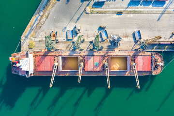 Aerial view from a drone of a large ship loading grain for export. Water transport
