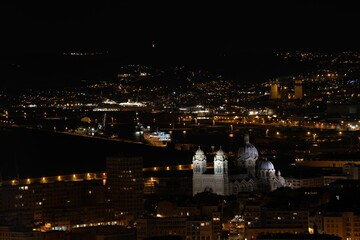Beautiful shot of Marseille Cathedral in Marseille, France at night with the illuminated cityscape