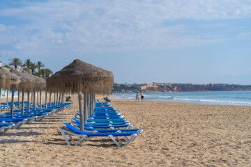 blue hammocks and thatched umbrellas on the beach for tourists