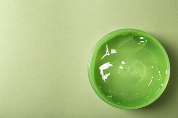 Aloe gel in jar on olive background, top view. Space for text
