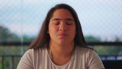 Portrait of a young diverse Asian adult girl in 20s with serious expression looking at camera