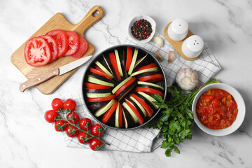 Dressing for delicious ratatouille and different vegetables on white marble table, flat lay