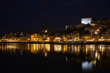 Low-angle view of modern buildings near the water at night in Oporto, Portugal