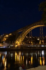 Fototapeta na wymiar Vertical shot of a beautiful bridge above the water in Oporto, Portugal