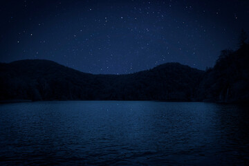Amazing starry sky reflecting in lake. Beautiful night landscape