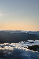 Obraz premium Winter landscape at sunrise with snowy mountains, clear and purple sky background
