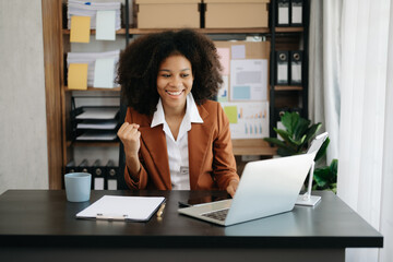 African business woman are delighted and happy with the work they do on their tablet, laptop and taking notes at the office.