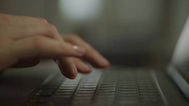 Unrecognizable woman hands typing on laptop keyboard