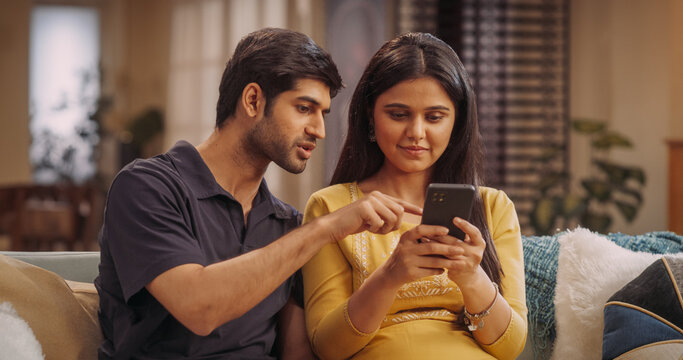 Indian Couple Engaged In Online Shopping, Scrolling Through Product Listings And Hunting For Bargains. Sharing Excitement Over Special Offers, Free Shipping, And Cashback Deals On Their Favorites.