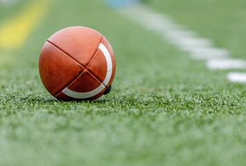 Selective focus of a football on green grass in a football field