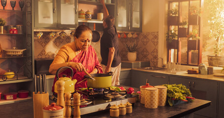 Charming Elderly Indian Couple Preparing Food Together: Laughing and Talking about their Day, Creating Delicious Meals, Sharing Love and Kindness in a Cozy Kitchen. 