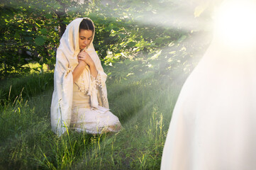 Praying woman in ancient light clothes