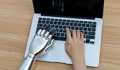 Robot hand and human hand using laptop