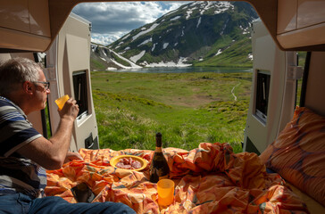 Man is relaxing in his van, Little St. Bernard Pass between France and Italy border - 605645639