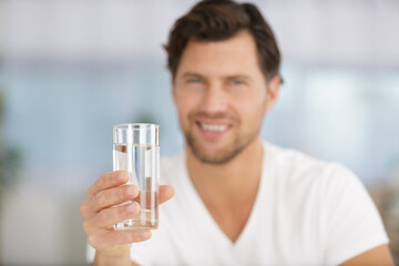 man holds out a glass of water